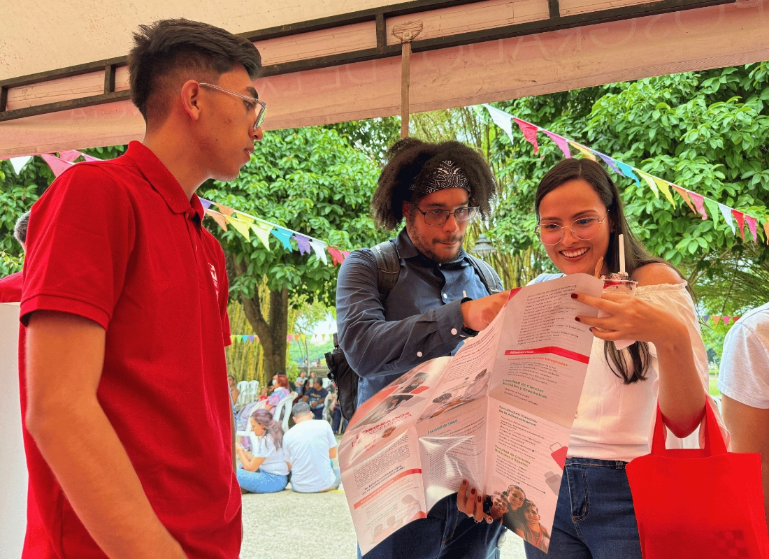 Entrega de bolsas institucionales y folletos de programas a los asistentes.