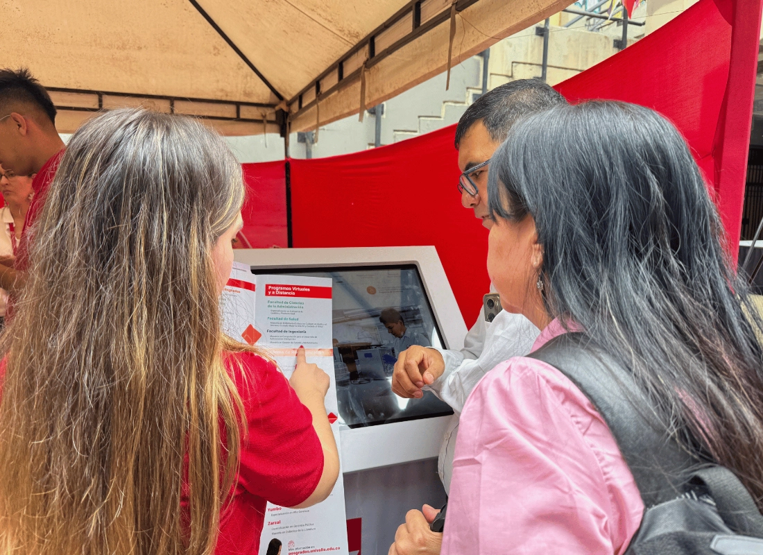 Uso de pantallas táctiles informativas por parte de los asistentes a la feria.