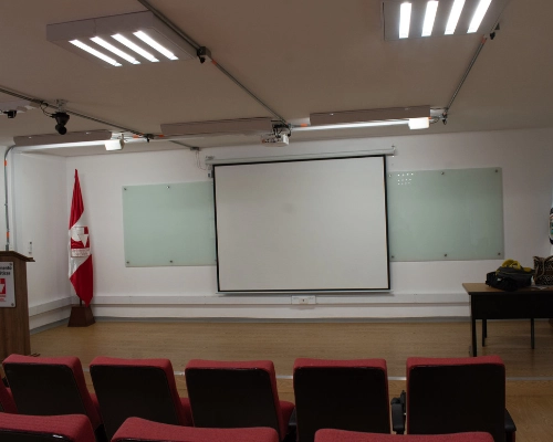 Vista del escenario del Auditorio Chepe Escobar con pantalla, tablero y silletería roja