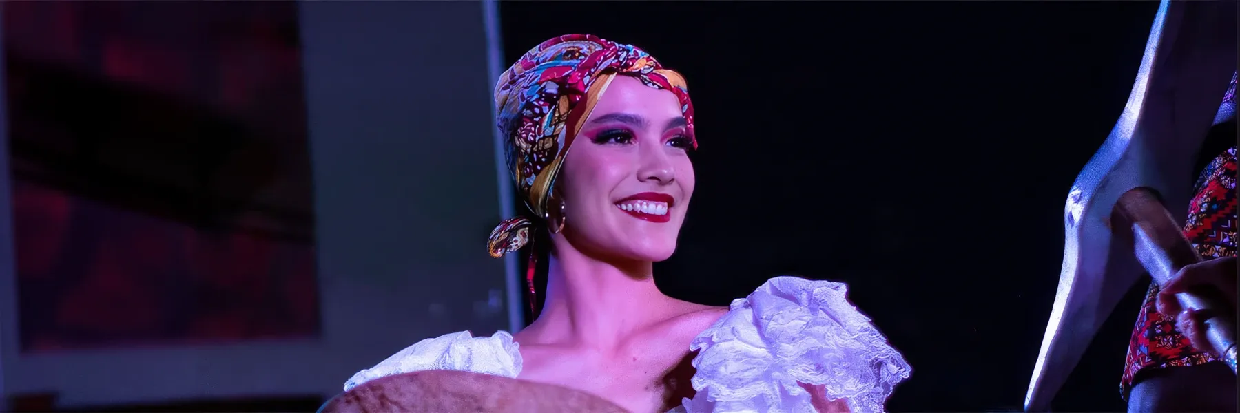 Bailarina sonriente con traje típico tradicional en el escenario