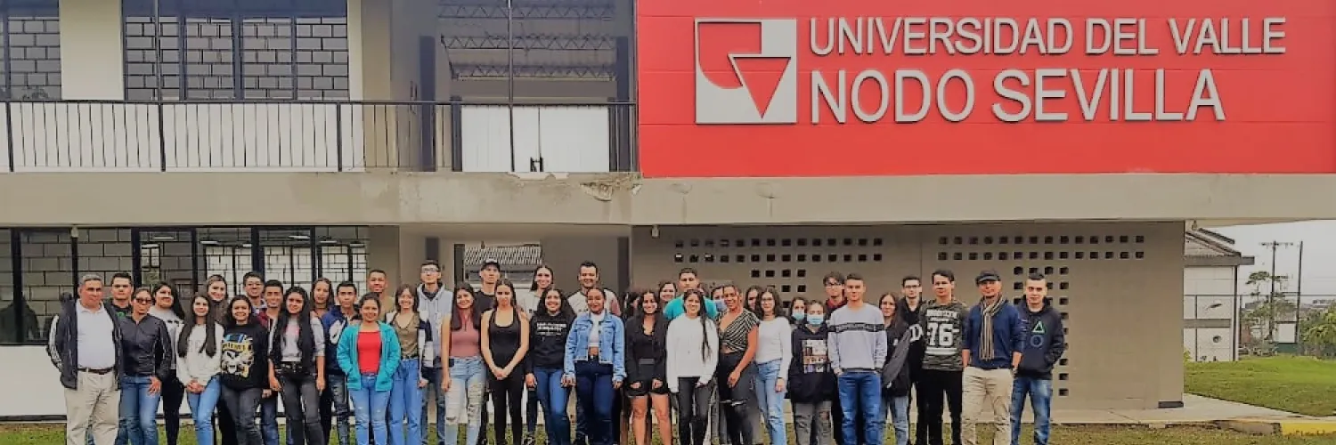 Grupo de estudiantes y docente posando frente a la Universidad del Valle Nodo Sevilla