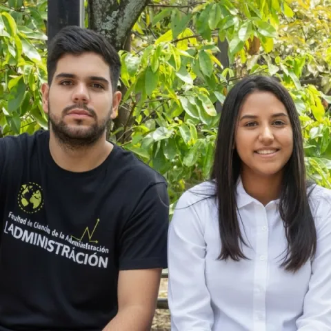 Dos estudiantes de Ciencias de la Administración posando en el campus universitario